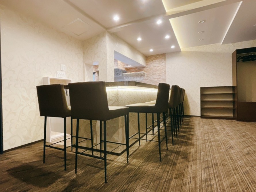 間接照明で演出したバーのバーカウンター内装。おしゃれな飲食店デザイン