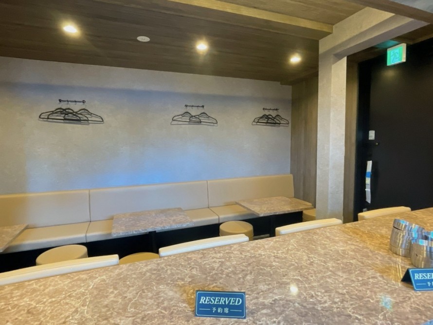 ベンチシートを設けたバーのテーブル席内装。飲食店改装によるおしゃれな空間