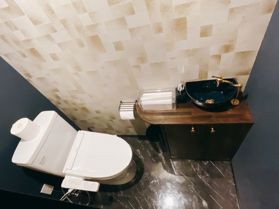 飲食店改装で施工したバーのトイレ内装デザイン。ネイビーとゴールドを組み合わせた高級感のある空間