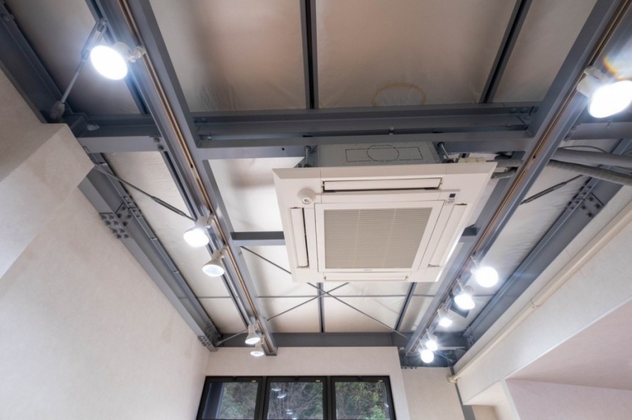 グレー塗装の鉄骨を露出させた美容院のスケルトン天井デザイン