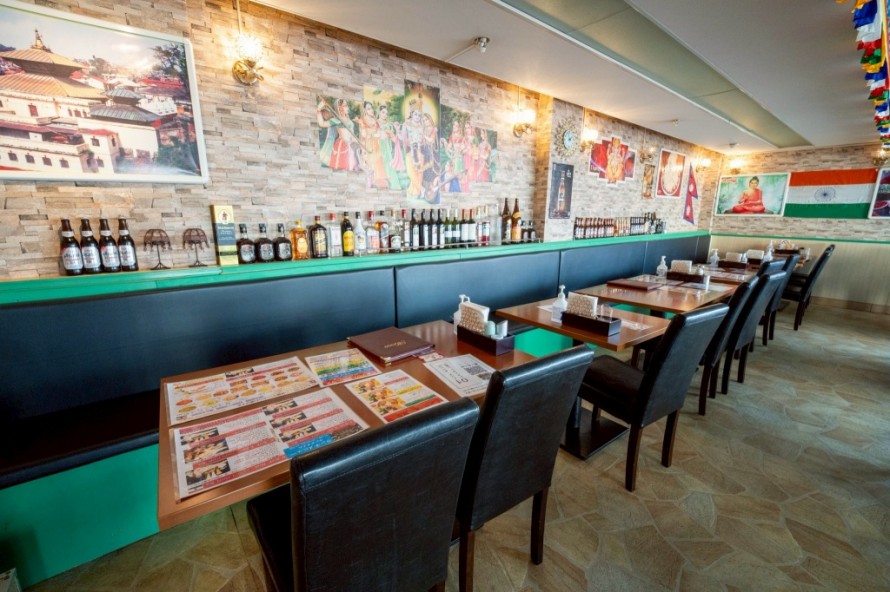 石目調クロスとボトル棚が印象的なエスニック飲食店内装