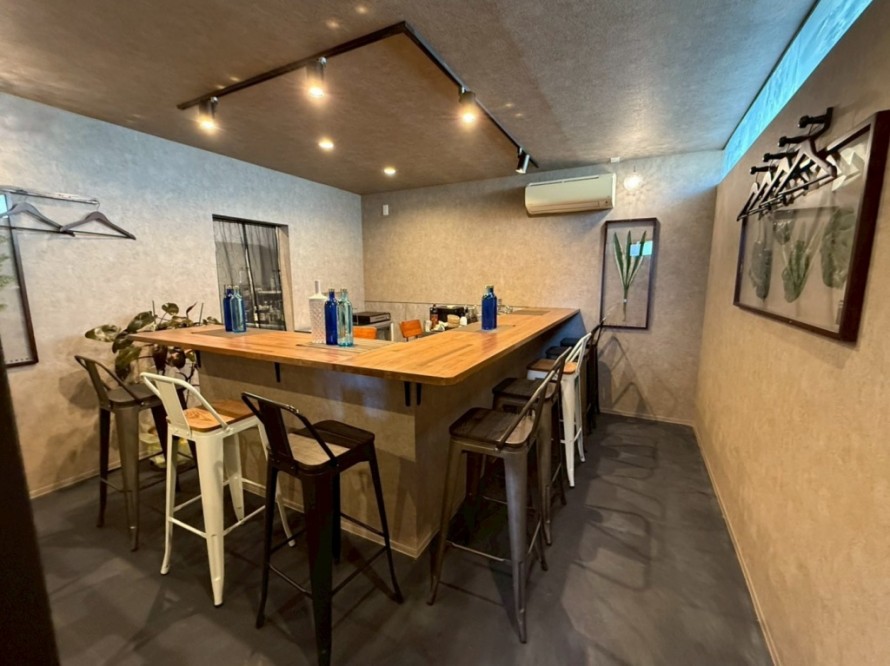 木製バーカウンターと間接照明のある居酒屋内装