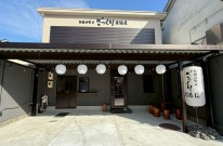 白と黒を基調に提灯が灯るおしゃれな居酒屋の外観デザイン