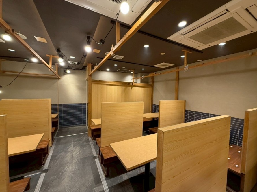 木製パーテーションで仕切られた居酒屋のテーブル席内装