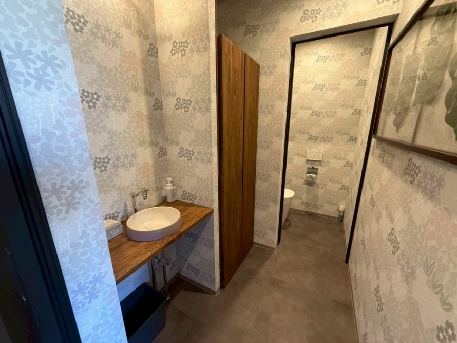 花柄壁紙と木製カウンターを使った居酒屋トイレ内装