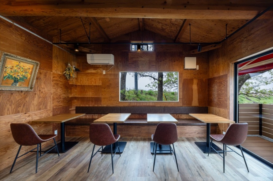 大きなピクチャーウィンドウがある隠れ家カフェのテーブル席