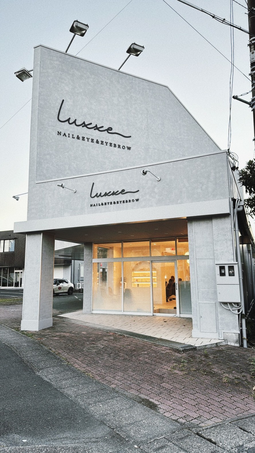 三角形ファサードが特徴的なモダンなサロン店舗の外観デザイン