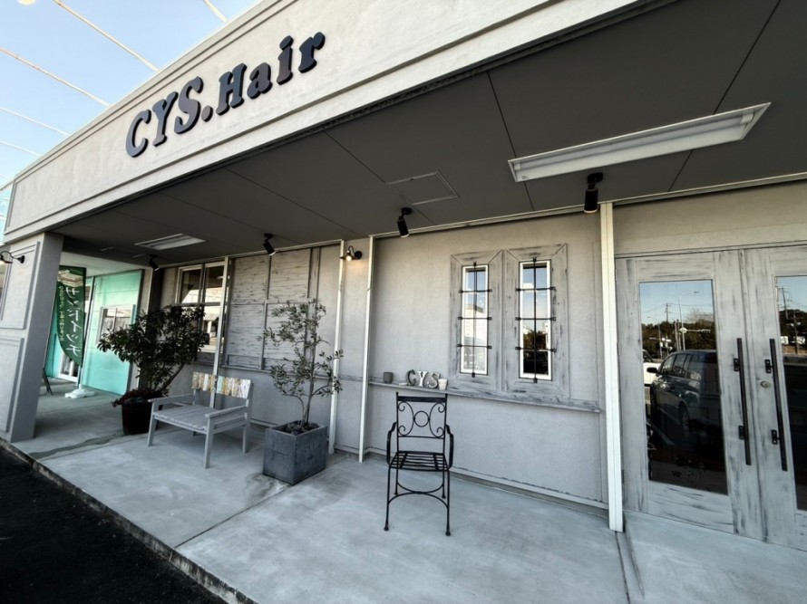 シャビーシックに仕上げられた美容室の白い外観とおしゃれな看板