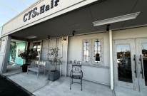 シャビーシックに仕上げられた美容室の白い外観とおしゃれな看板