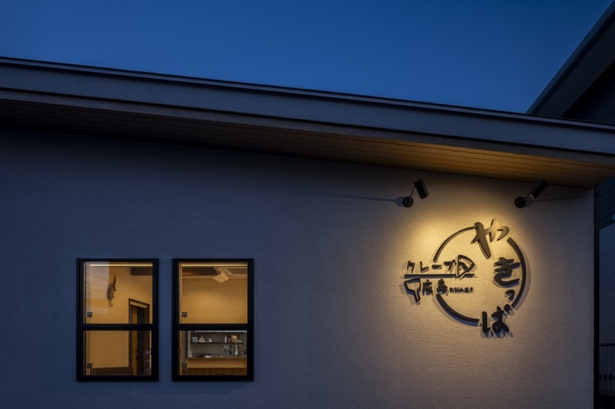 夜にライトアップされた店舗ロゴと看板